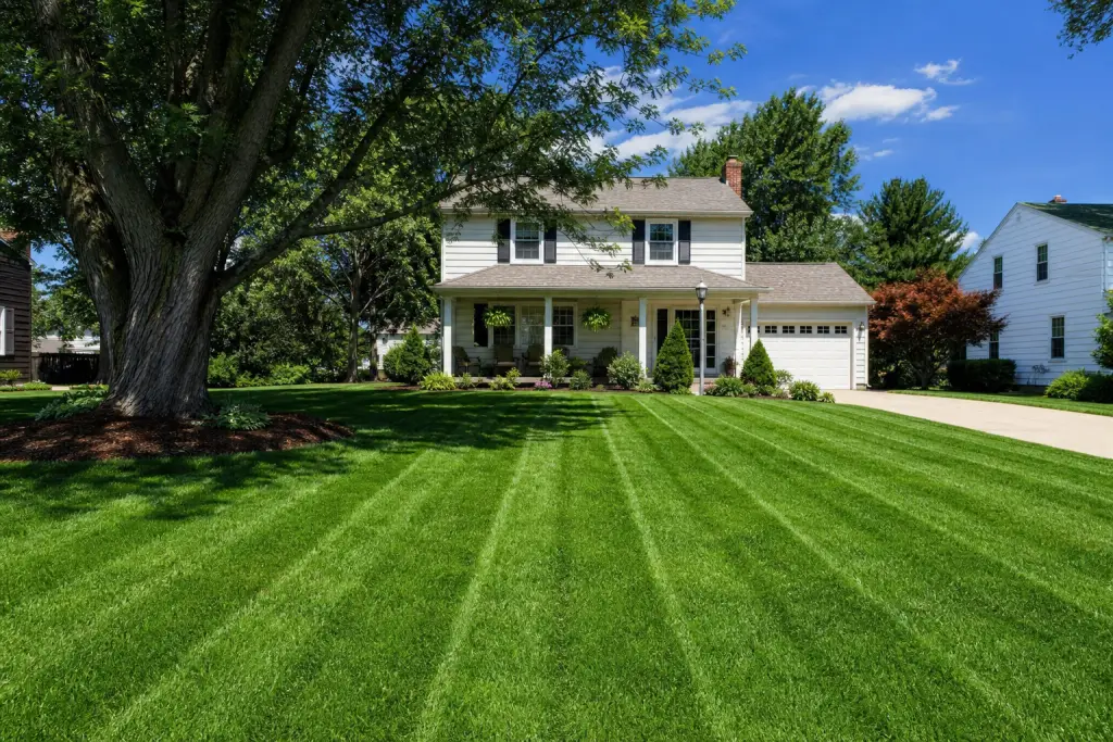 Professional lawn maintenance in Lancaster, Ohio with a healthy striped lawn in front of a well-maintained home
